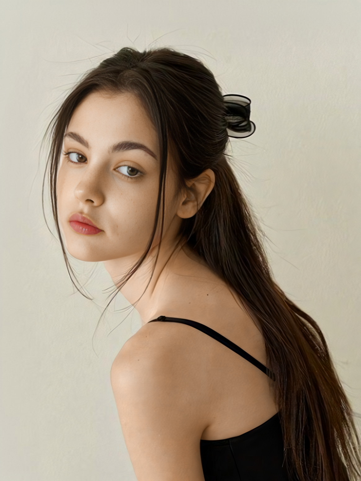 图片展示了一位女性，她侧身面向画面左侧，头发为深棕色，部分头发用黑色发夹固定。她穿着黑色吊带背心，背景为浅色。该图片位于“使用步骤”部分，用于说明在LinkFoxAI一键换色功能中，上传需要换色的图片时，可选择此类纯色商品图片进行操作。
