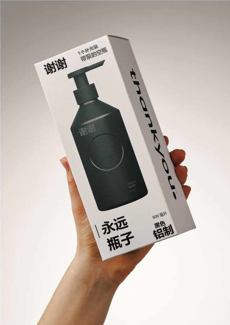 图片展示了一只手拿着的“谢谢”品牌产品包装盒。包装盒为白色，正面印有黑色的“谢谢”字样及“永远瓶子”等文字，侧面有“1个补充装 带泵的空瓶”等信息，底部标注“500毫升 黑色 铝制”。包装盒内是黑色的带泵空瓶，瓶身简洁，瓶盖处有“谢谢”标识。该图片与文档中“产品包装图”部分对应，用于展示上传图片需保证文字清晰可见的要求。